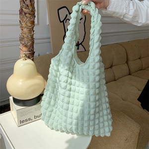 Detail of mint green quilted tote bag with bubble texture and soft handle strap