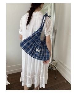 Detail of blue plaid tote bag featuring a cute drawstring bow and soft cotton fabric texture