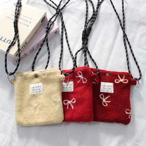 Floral felt crossbody bags in cream and red colors with adjustable woven straps and bows