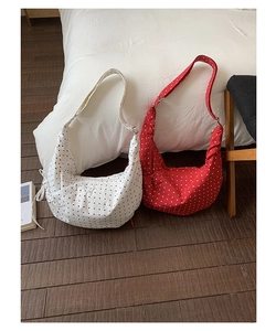 Polka dot canvas saddle bags in red and white colors with pleat details and adjustable straps