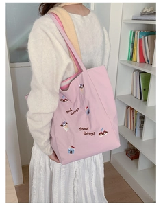 Détails de la broderie de chiot et gâteau sur un grand sac fourre-tout en toile rose
