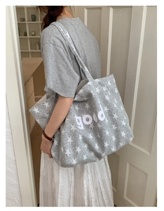 Detail of grey canvas tote bag with star pattern and good text for student use