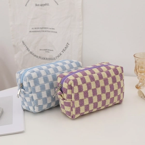Detailed close-up of checkered knit makeup bag texture and durable metal zipper closure