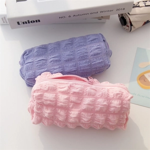 Detailed view of pink and purple quilted pencil cases with textured puff fabric and zippers