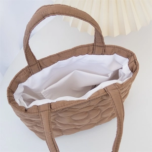 Close-up of brown quilted bag showing white lining and internal pocket storage