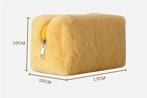 Macro shot showing dimensions of the yellow plush makeup bag with soft fuzzy texture