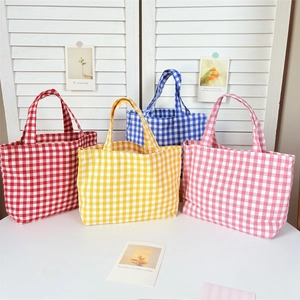 Detailed view of checkered gingham tote bags in red, yellow, blue, and pink cotton fabric