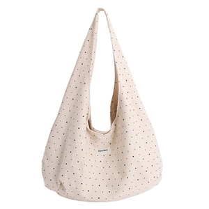 Minimalist beige canvas hobo tote bag featuring black star pattern and Merci label