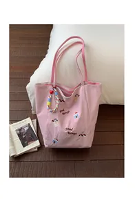 Détail du cabas en toile rose avec broderie Good Things et écussons de dessins animés