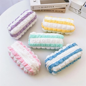 Flat lay of five colorful seersucker pencil cases with ruffled texture and white zippers