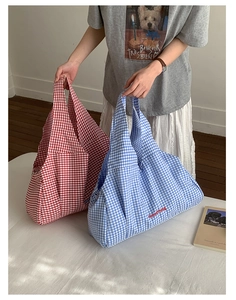 Detail of checkered tote bags in red and blue with GoodThing embroidery on canvas