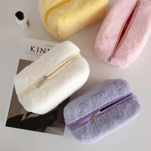 Soft macaron plush makeup bags in yellow pink white and purple on white surface