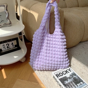 Close-up of lavender puff textured fabric on the integrated shoulder strap tote bag