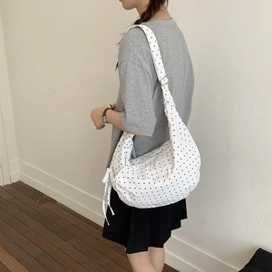 Polka dot crossbody hobo bag with drawstring bow detail and adjustable wide shoulder strap