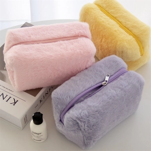 Detailed close-up of macaron colored plush cosmetic bags in pink, purple, and yellow faux fur