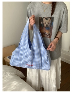 Blue and white gingham tote bag with red GoodThing embroidery shown held by a model