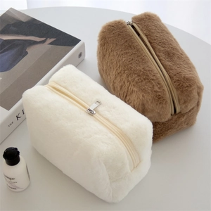 Detail of plush square cosmetic bags in cream and brown with soft faux fur and zip closure