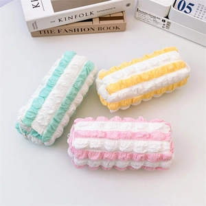 Macro detail of puffy ruffled texture on mint green, pink and yellow pencil cases