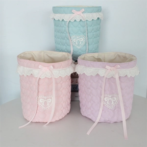Pastel fabric storage baskets with lace trim and ribbon bows for desktop organizing