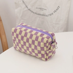 Detail of purple checkered knit makeup bag with zipper closure and soft texture