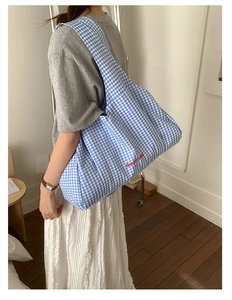 Detail shot of blue gingham tote bag featuring red GoodThing embroidery and fabric texture
