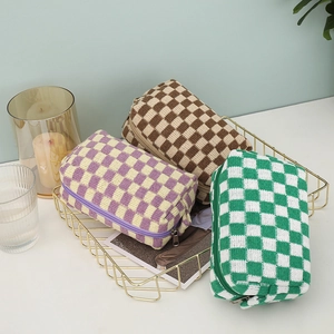 Detailed knit texture of checkerboard cosmetic bags in various colors with zipper pull
