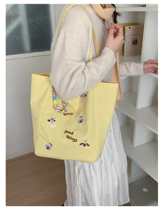 Détail de la broderie et de la bandoulière tissée colorée sur le sac fourre-tout en toile