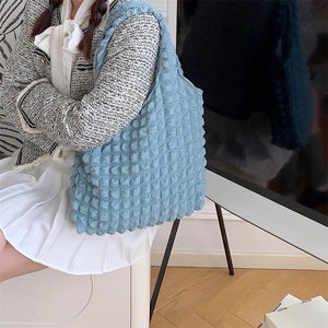 Detailed view of light blue quilted bubble texture fabric on a shoulder tote bag