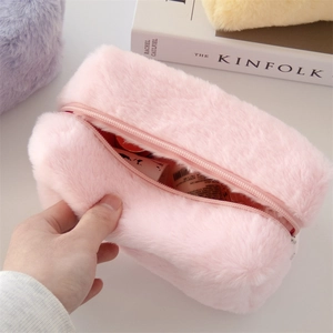 Macro detail of soft pink plush makeup bag with zipper closure and spacious interior
