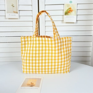 Detail of yellow and white gingham canvas tote bag with reinforced top handles