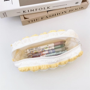 Close-up of yellow plush ruffled pencil case with top zipper and stationery storage