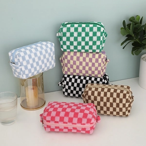 Close-up of checkerboard knit makeup bags in multiple colors with zipper details
