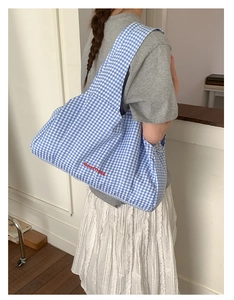Detail of blue plaid tote bag with red GoodThing embroidery shown on shoulder