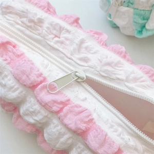 Close-up of pink and white seersucker pencil case showing high-quality resin zipper detail