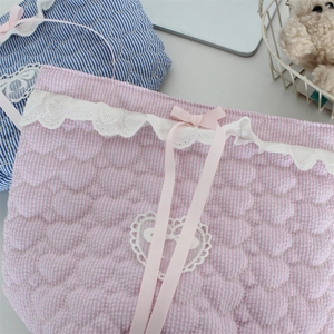 Close-up of heart-quilted fabric storage basket with delicate lace trim and pink ribbon bow