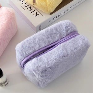 Macro shot of fluffy macaron plush makeup bags in pastel purple, pink and yellow