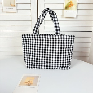 Detail of the black and white checkerboard canvas tote bag with sturdy top handles