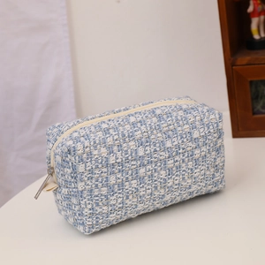 Blue and white tweed makeup bag with woven texture and large capacity shown at a 45-degree angle