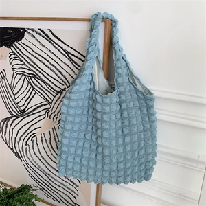Close-up of blue cloud bubble texture fabric on a minimalist tote bag with shoulder straps