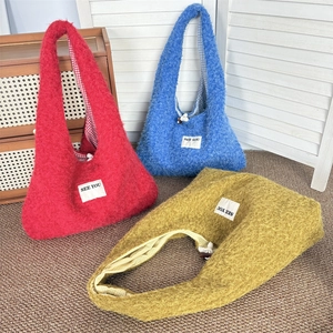 Detailed plush hobo bags in red, blue, and lime green with soft fuzzy texture and plaid lining