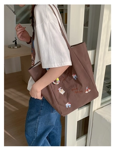 Détail d'un grand sac cabas en toile marron avec de jolies broderies et doubles anses