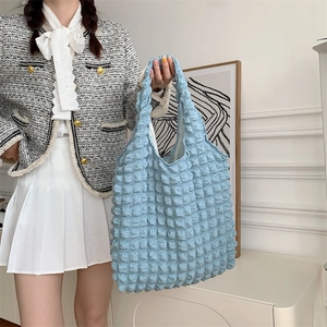 Detail of light blue bubble textured tote bag with quilted pattern for women's daily use