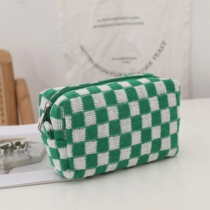 Close-up of green and white checkered knit pouch with durable silver metal zipper detail