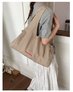 Detail of checkered canvas tote bag with GoodThing embroidery on spacious daily carryall