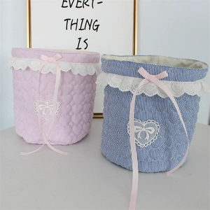 Close-up of quilted fabric storage baskets with delicate lace edges and pink ribbon bows