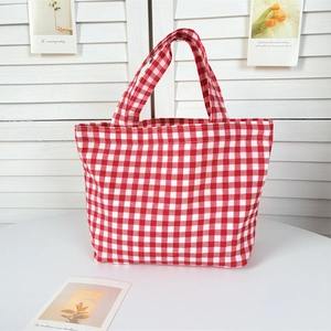 Close-up of red and white gingham canvas tote bag on a minimalist white table