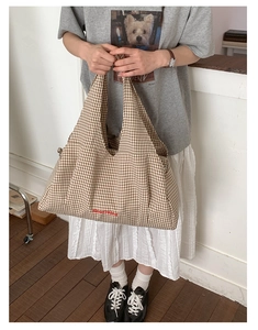 Detailed view of red GoodThing embroidery on a brown and white checkered canvas tote bag