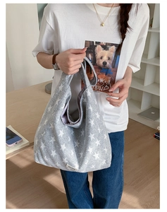 Detail view of the star printed canvas hobo bag with adjustable strap and brand tag