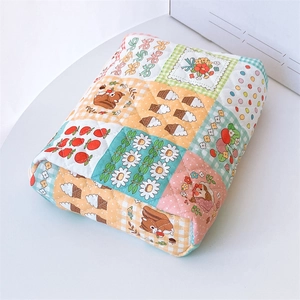 Close-up of quilted cotton storage bag featuring cute patchwork floral and animal prints