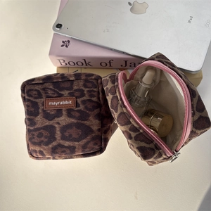 Detailed interior of a suede leopard print cosmetic bag showing makeup storage capacity